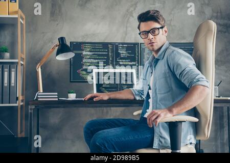 Portrait of his he nice skilled expert geek guy company owner technician sitting in chair coding task solving at modern industrial interior style Stock Photo