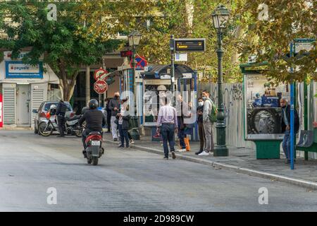 Thessaloniki, Greece - November 02 2020: People with covid-19 masks at a bus stop. Unidentified crowd with face protection waiting for an OASTH public transportation vehicle in the city centre. Stock Photo