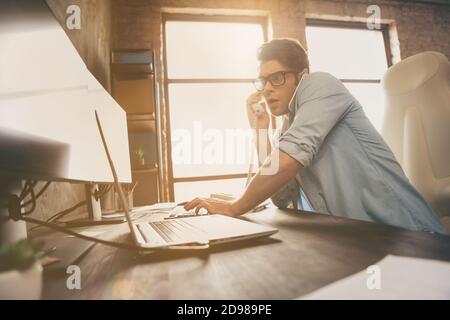 Portrait of his he nice attractive busy overwhelmed guy digital manager answering calls solving web site problem at modern industrial interior loft Stock Photo