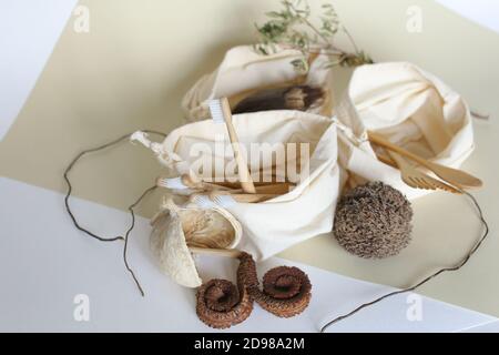 Wooden spoons and forks, toothbrushes in tissue pouch. Stock Photo