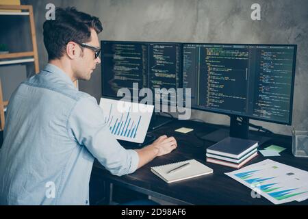Profile side view portrait of his he nice attractive focused skilled guy geek coding programming writing database source at modern industrial interior Stock Photo