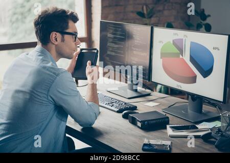 Profile side photo of focused guy it specialist sit desk work pc look charts analyze start-up javascript cyber website progress in workplace Stock Photo