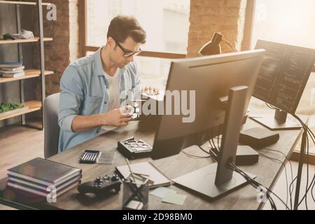 Portrait of his he nice attractive busy skilled experienced focused geek guy repairing part pc cpu hard disk drive handiwork at modern loft brick Stock Photo