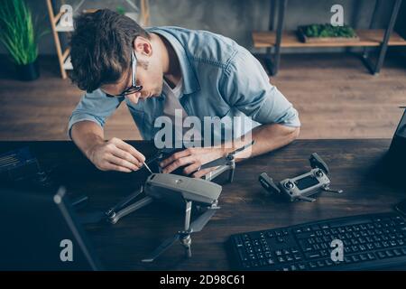 Portrait of his he nice attractive focused experienced guy geek expert repairing drone detail practicing quarantine health staying at modern Stock Photo