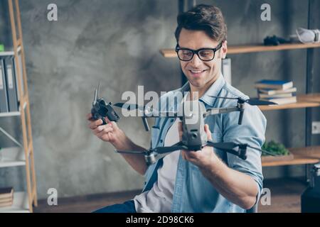 Portrait of his he nice attractive focused cheerful cheery guy geek professor holding in hands drone novelty invent security safety at modern loft Stock Photo