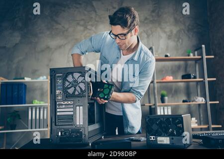 Portrait of his he nice attractive focused busy hardworking professional guy geek technician repairing hardware detail fixing order at modern loft Stock Photo