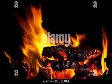 Live coals with fire flames on black background Stock Photo