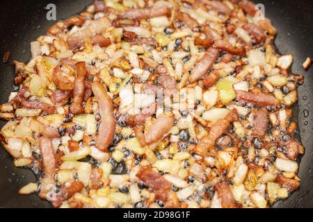 Photo of a delicious bacon lard with onions. Fried in boiling oil in a pan. Cooking concept. Close-up Stock Photo