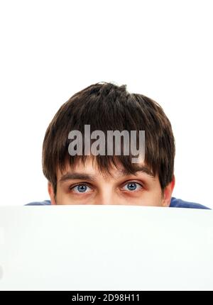 Surprised Young Man behind the Blank Paper on the White Background Stock Photo