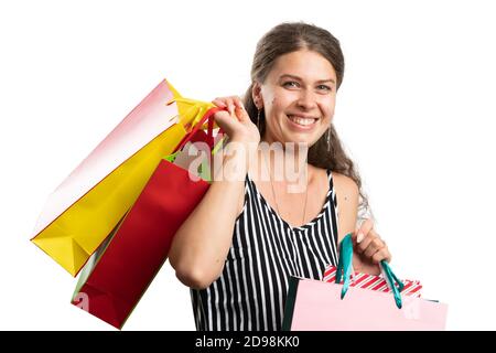 Cheerful female adult model wearing modern casual summer outfit carrying colourful bags after shopping spree as consumerism concept isolated on white Stock Photo