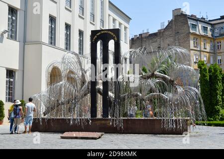 Tourists visit Raoul Wallenberg Holocaust Memorial Park, Memorial of the Hungarian Jewish Martyrs with weeping willow tree, in Budapest, Hungary Stock Photo