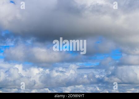 Bright blue sky with dramatic cumulus clouds lit by the daytime sun. Abstract background. Stock Photo
