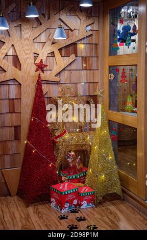 Shanghai, China - 10 24 2020: Alternative creative Christmas trees with golden string lights and holiday gift boxes. Handmade sparkly Christmas tree a Stock Photo