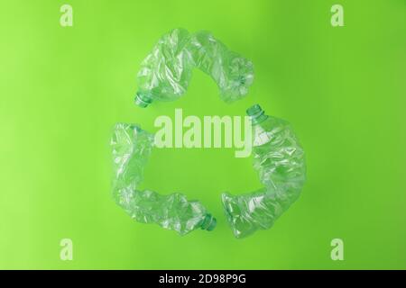 Recycling Symbol Made with Three Plastic Bottles on Green Background Stock Photo