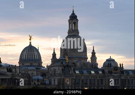 Dresden, Germany. 03rd Nov, 2020. The glass dome of the Academy of Fine Arts (l) with the trombone angel Fama and the Frauenkirche at sunset. Credit: Sebastian Kahnert/dpa-Zentralbild/ZB/dpa/Alamy Live News Stock Photo
