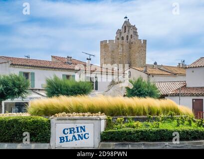 'Crin Blanc' (White Mane) white horse sculpture at Place Honoré Pioch against the backdrop of the fortified Church of Notre-Dame-de-la-Mer, Saintes-Ma Stock Photo