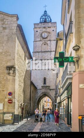 The Tour de l’Horloge, Clock Tower seen through the narrow Rue des Marchands in the ancient Luberon City of Apt, Vaucluse department, Provence-Alpes-C Stock Photo