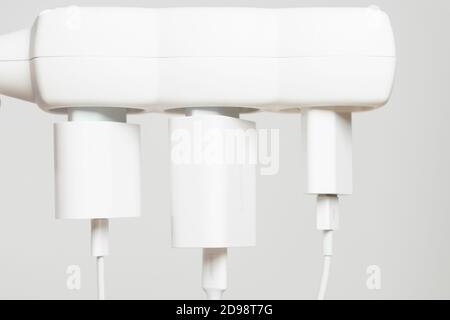 Indoor white office extension cord with three white connected to it power plugs with copy space Stock Photo