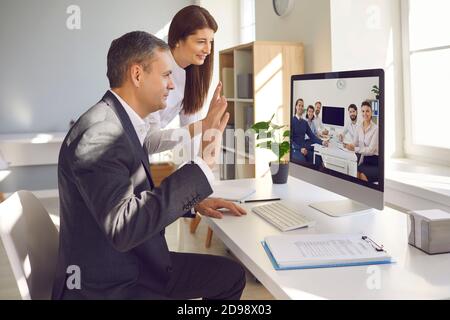 Teams of happy company workers from different departments having video conference Stock Photo