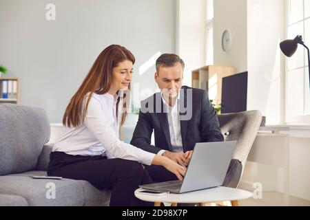 Two serious business people meeting in the office and working on project using laptop computer Stock Photo