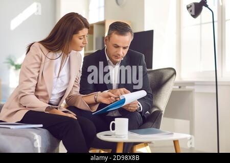 Serious business people reading commercial contract and discussing its pros and cons Stock Photo