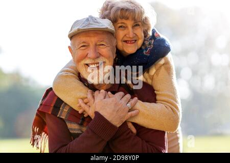 Happy senior couple spending time together in beautiful city park in autumn Stock Photo