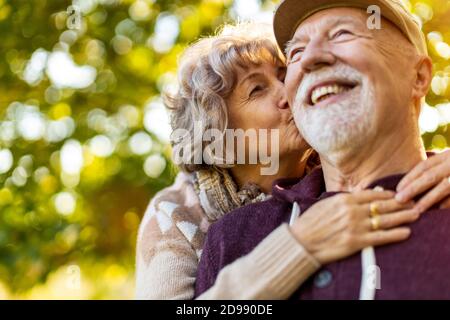 Happy senior couple spending time together in beautiful city park in autumn Stock Photo