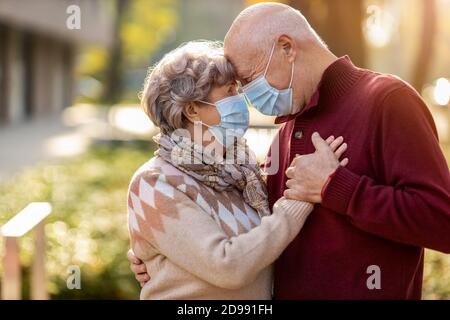 Portrait of senior couple wearing protective face masks outdoors Stock Photo