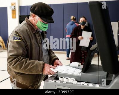 Wisconsin, USA. 3rd Nov, 2020. A voter places his ballot into a ballot box at a polling station in Kenosha, Wisconsin, the United States, on Nov. 3, 2020. Voting on Election Day is underway across the United States, as the COVID-19 pandemic is raging on and political divide running deeper. Credit: Joel Lerner/Xinhua/Alamy Live News Stock Photo