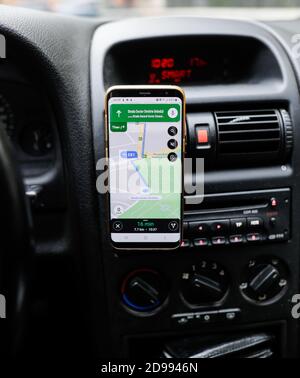 Bucharest, Romania - October 25, 2020: Shallow depth of field (selective focus) image with the Google Maps app on a mobile device in a car. Stock Photo