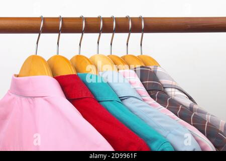 Different women's office classic shirts hang on a hanger for storing clothes. The choice of style of fashionable clothes Stock Photo