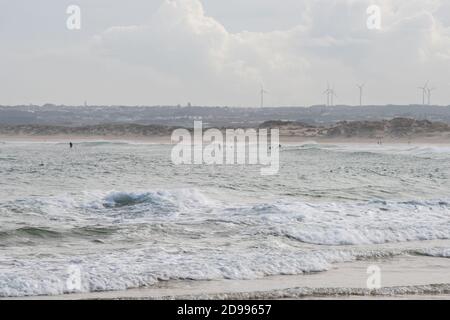 Surfers surfing in Peniche beach atlantic ocean waves in Portugal Stock Photo