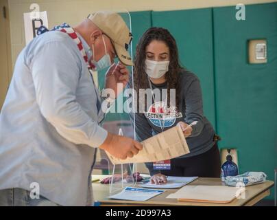 Arlington, VA, November 3, 2020, USA:Voters in Arlington, VA cast their ballots in the Presidential and local elections. An Election official assists a voter with his ballot. Patsy Lynch/MediaPunch Credit: MediaPunch Inc/Alamy Live News Stock Photo