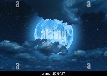 Blue super moon glowing against cloudy sky Stock Photo