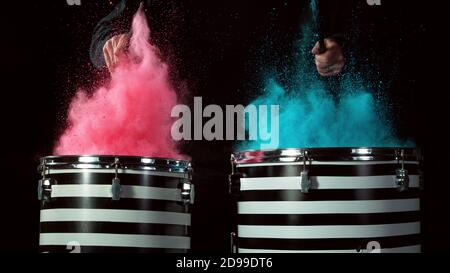 Freeze motion of coloured powder explosion on drums isolated on black background Stock Photo