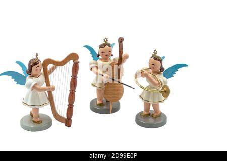 Closeup of a group of original handcarved wooden German Christmas Angel figurines with music instruments as orchestra on a white background Stock Photo