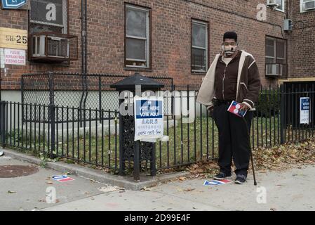 A man wearing a mask waits outside a polling site for his turn to vote in the 2020 USA presidential election. Stock Photo