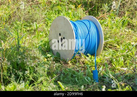 Cable drum with network cord on green meadow field Stock Photo