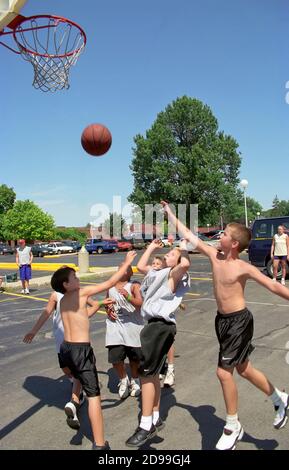 3 on 3 boys basketball action in a tournment for players of all ages Stock Photo