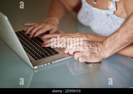 Close-up of the hands of an adult man and a woman on the laptop Stock Photo