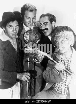 1930 , USA  :  The  MARX  BROTHERS : Harpo ( 1893 - 1964 )  , Chico ( 1891 - 1961 ) , Zeppo ( 1901 - 1979 ) and Groucho  ( 1895 - 1977 ) ,  pubblicity still for the first talkies movie ANIMAL CRACKERS   by Victor Heerman . - microfono - microphone ----   Archivio GBB Stock Photo
