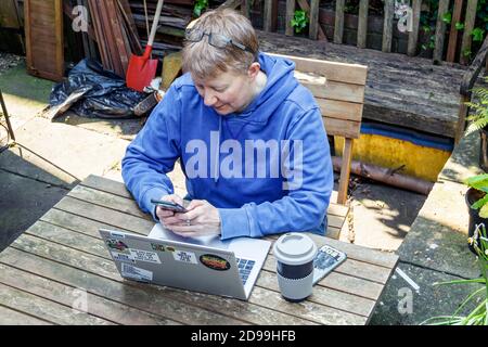 A female consultant doctor in casual clothing working from home during the coronavirus lockdown, London, UK Stock Photo