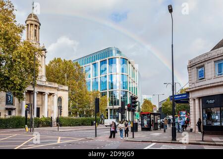 A rainbow arcs above Great Portland Street Tube and Commonwealth Church on Marylebone Road on a sunny October afternoon, London, UK Stock Photo