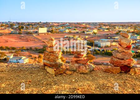 Stacked stones in Coober Pedy skyline in Australia from lookout cave with city downtown buildings. Australian outback desert of South Australia. Stock Photo