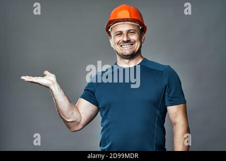 Engineer in hardhat pointing to the left side of the image Stock Photo