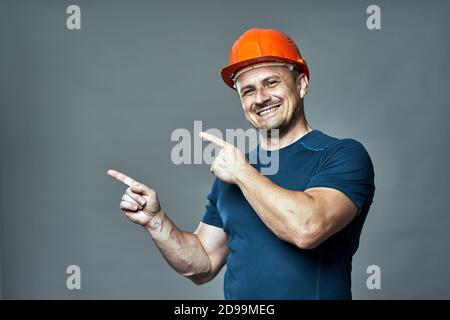 Engineer in hardhat pointing to the left side of the image Stock Photo