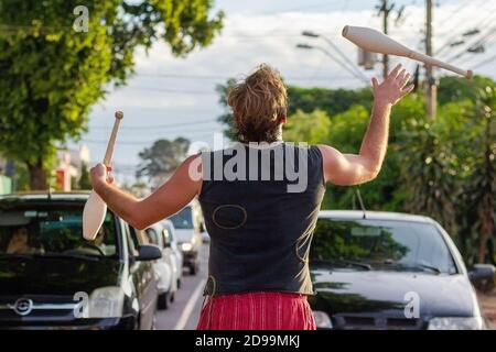 Ribeirao Preto, SP, BRAZIL - February 13 2015: juggler performing in front of cars, waiting at traffic lights, after the performance he asks the drive Stock Photo