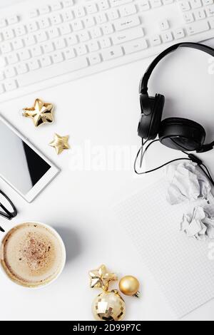 christmas workspace with notebook keyboard, headphones, coffee and christmas ornaments on white Stock Photo