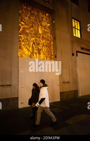 New York, NY, USA. 3rd Nov, 2020. New York City anticipates presidential election results as polls in some states close. A couple walks by the boarded-up Michael Kors store in Rockefeller Center. Credit: Ed Lefkowicz/Alamy Live News Stock Photo