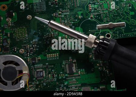 use a soldering iron to solder the electronic part to the Board. Computer repair. Macrophotography. Stock Photo